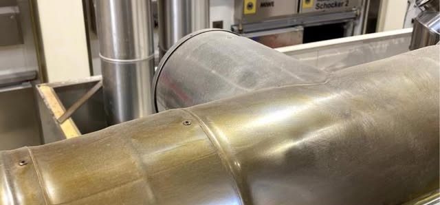 Verschmutztes Edelstahlrohr in einer Großbäckerei